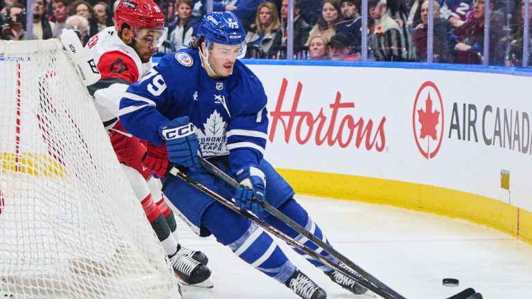 Toronto Maple Leafs' Sammy Blais (79) and Carolina Hurricanes' K'Andre Miller (19) battle for the puck during second period NHL hockey action in Toronto, on Sunday, Nov. 9, 2025. (Sammy Kogan/CP)