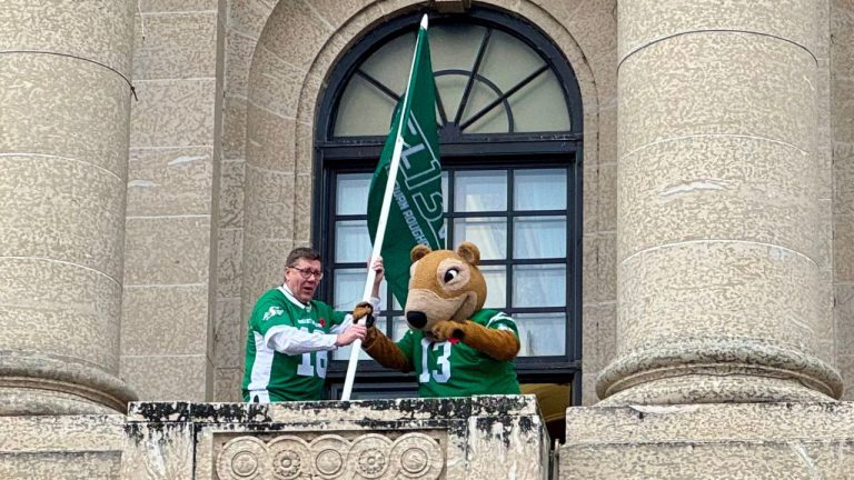 Saskatchewan Premier Scott Moe and the CFL's Saskatchewan Roughriders mascot, Gainer the Gopher, raise a flag outside the legislature on Thursday, Nov. 6, 2025, in Regina, marking Friday as Green and White Day ahead of the CFL's West final against the B.C. Lions. THE CANADIAN PRESS/Jeremy Simes
Jeremy Simes