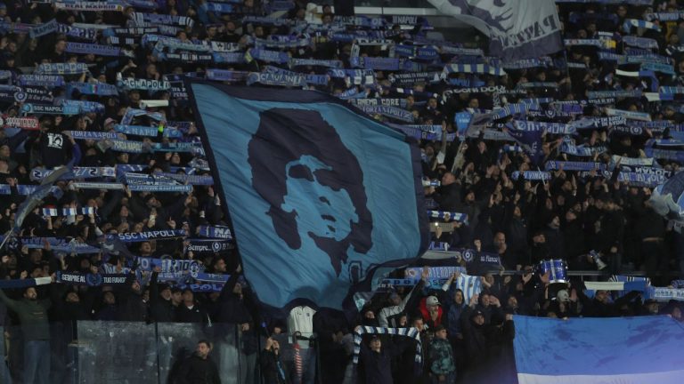 Napoli's supporters hold up a Diego Maradona flag during the Champions League opening phase soccer match between Napoli and Qarabag in Naples, Italy, Tuesday Nov. 25, 2025. (Alessandro Garofalo/AP)