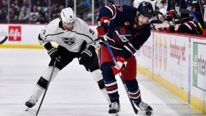 Winnipeg Jets' Adam Lowry (17) shoots the puck as he is checked by Los Angeles Kings' Adrian Kempe (9) during second period NHL action in Winnipeg on Tuesday February 28, 2023. (Fred Greenslade/CP)