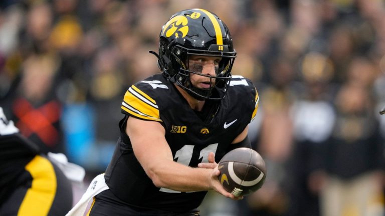 Iowa quarterback Mark Gronowski looks to hand the ball off during the second half of an NCAA college football game against Minnesota, Saturday, Oct. 25, 2025, in Iowa City, Iowa. (AP Photo/Charlie Neibergall)