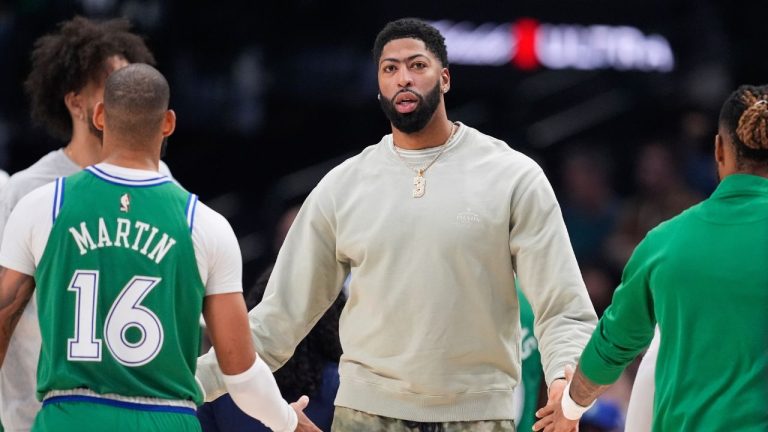 Dallas Mavericks' Anthony Davis, center, greets Caleb Martin and others walking off the court during a time out in the first half of an NBA game against the Phoenix Suns Thursday,Nov. 13, 2025, in Dallas. (AP Photo/Tony Gutierrez)