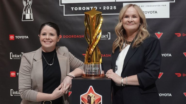 Diana Matheson, left, co-founder and chief growth officer of the Northern Super League, and NSL president Christina Litz pose in Toronto, on Thursday, Nov. 13, 2025, next to the Diana B. Matheson Cup, which will be awarded after Saturday's championship game between AFC Toronto and Vancouver Rise FC. (CP/Neil Davidson)