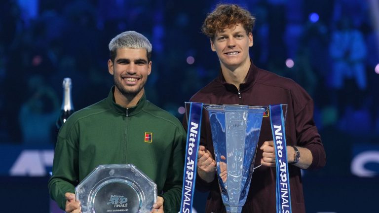 Spain's Carlos Alcaraz, left, and winner Italy's Jannik Sinner stand on the podium after the final tennis match of the ATP World Tour Finals, in Turin, Italy, Sunday, Nov. 16, 2025. (AP Photo/Antonio Calanni)