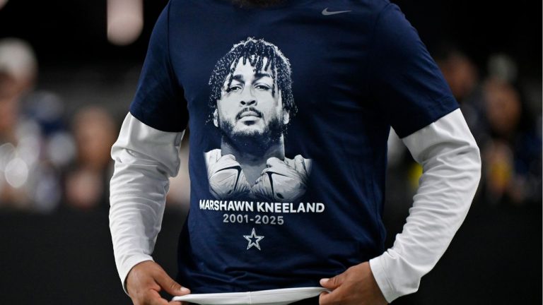 A Dallas Cowboys player wears a tribute t-shirt with Cowboys' Marshawn Kneeland on it prior to an NFL football game against the Las Vegas Raiders Monday, Nov. 17, 2025, in Las Vegas, in memory of Kneeland who passed away earlier this month. (David Becker/AP)