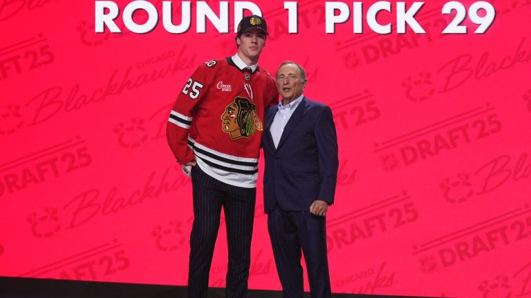 Mason West, left, stands with NHL commissioner Gary Bettman after being drafted by the Chicago Blackhawks during the NHL draft Friday, June 27, 2025, in Los Angeles. (AP/Damian Dovarganes)
