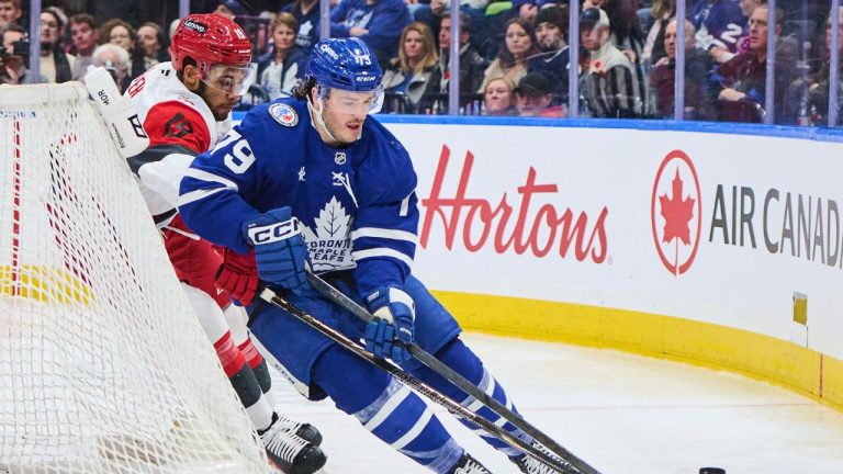 Toronto Maple Leafs' Sammy Blais (79) and Carolina Hurricanes' K'Andre Miller (19) battle for the puck during second period NHL hockey action in Toronto, on Sunday, Nov. 9, 2025. (Sammy Kogan/CP)