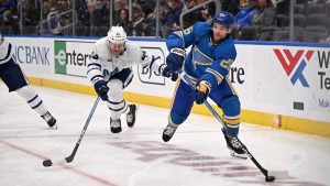 St. Louis Blues' Nathan Walker (24) passes the puck while pressured by Toronto Maple Leafs' Morgan Rielly (44), left, during the second period of an NHL hockey game Saturday, Nov. 2, 2024, in St. Louis. (Connor Hamilton/AP)