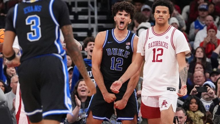 Duke forward Cameron Boozer (12) celebrates after scoring as Arkansas forward Malique Ewin (12) looks on during the second half of an NCAA college basketball game in the CBS Sports Thanksgiving Classic tournament Thursday, Nov. 27, 2025, in Chicago. (Nam Y. Huh/AP Photo)