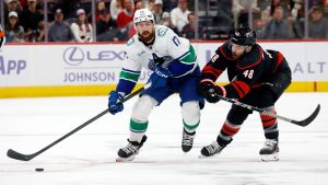 Carolina Hurricanes' Jordan Martinook (48) pesters Vancouver Canucks' Filip Hronek (17) as he controls the puck during the first period of an NHL hockey game in Raleigh, N.C., Friday, Nov. 14, 2025. (Karl DeBlaker/AP)