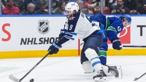 Winnipeg Jets' Alex Iafallo (9) gets away from Vancouver Canucks' Quinn Hughes (43) while skating with the puck during the second period of an NHL hockey game in Vancouver, on Tuesday, November 11, 2025. (Darryl Dyck/CP)