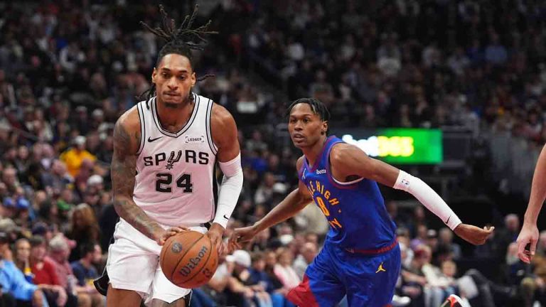 San Antonio Spurs guard Devin Vassell, left, drives the lane past Denver Nuggets guard Peyton Watson in the first half of an NBA Cup basketball gam,e Friday, Nov. 28, 2025, in Denver. (David Zalubowski/AP)