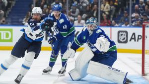 Winnipeg Jets' Gabriel Vilardi (13) redirects the puck in front of Vancouver Canucks goalie Thatcher Demko (35) and Elias Pettersson (40) during the first period of an NHL hockey game in Vancouver, on Tuesday, November 11, 2025. (Darryl Dyck/CP)