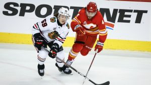 Chicago Blackhawks' Tyler Bertuzzi, left, checks Calgary Flames' Rasmus Andersson during third period NHL hockey action in Calgary on Friday, Nov. 7, 2025. (Jeff McIntosh/CP)