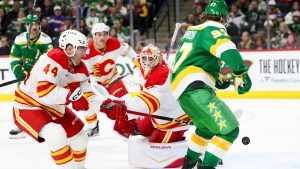 Minnesota Wild left wing Kirill Kaprizov (97) attempts to score on Calgary Flames goaltender Devin Cooley, center, while Flames defenseman Joel Hanley (44) guards the net during the third period of an NHL hockey game Sunday, Nov. 9, 2025, in St. Paul, Minn. (Ellen Schmidt/AP)