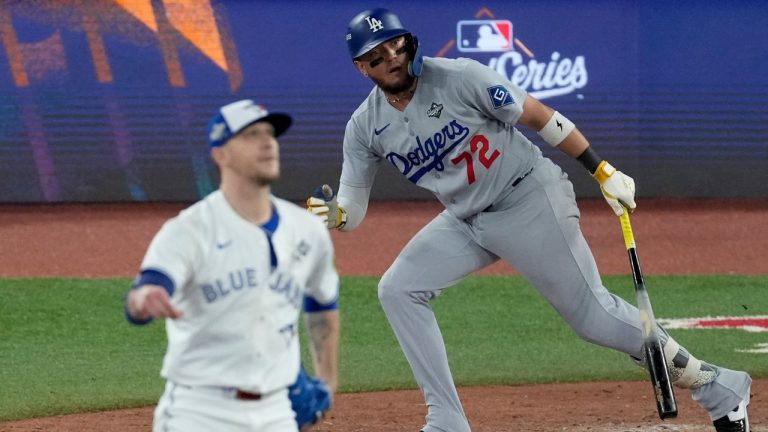 Los Angeles Dodgers' Miguel Rojas and Toronto Blue Jays' pitcher Jeff Hoffman, left, watch Rojas' home run take flight during the ninth inning in Game 7 of baseball's World Series, Saturday, Nov. 1, 2025, in Toronto. (Ashley Landis/AP Photo)