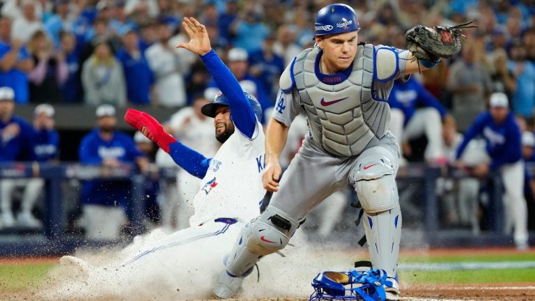 Toronto Blue Jays' Isiah Kiner-Falefa (7) is forced out at home plate by Los Angeles Dodgers catcher Will Smith (16) during ninth inning Game 7 World Series playoff MLB baseball action in Toronto on Saturday, Nov. 1, 2025. (Frank Gunn/CP)