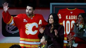 Calgary Flames' Nazem Kadri is honoured with a silver stick for his 1000th NHL game alongside his wife Ashley Cave and daughter Naylah prior to game action against the Columbus Blue Jackets in Calgary on Wednesday, Nov. 5, 2025. (Larry MacDougal/CP)