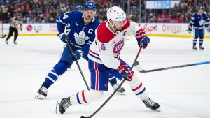 Montreal Canadiens' Nick Suzuki (14) shoots the puck as Toronto Maple Leafs' Auston Matthews (34) looks on during third period NHL action in Toronto on Saturday, April 12, 2025. (Arlyn McAdorey/CP)
