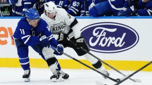 Toronto Maple Leafs' Max Domi (11) and Los Angeles Kings' Warren Foegele (37) battle for the puck during first period NHL hockey in Toronto on Thursday, November 13, 2025. (Nathan Denette/CP)
