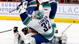Vancouver Canucks' Kevin Lankinen (32) snares the puck in front of a crashing Carolina Hurricanes' Logan Stankoven (22) during the second period of an NHL hockey game in Raleigh, N.C., Friday, Nov. 14, 2025. (Karl DeBlaker/AP)