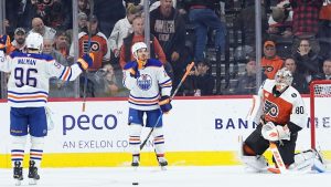 Edmonton Oilers' Jack Roslovic, centre, accompanied by Jake Walman, celebrates after scoring on Philadelphia Flyers goaltender Dan Vladar in overtime of an NHL hockey game, Wednesday, Nov. 12, 2025, in Philadelphia. (Matt Rourke/AP)