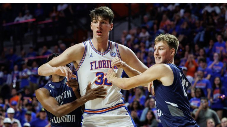  North Florida guard Dante Oliver, left and North Florida forward Nestor Dyachok, right, guard against Florida centre Olivier Rioux, centre, during the second half of an NCAA college basketball game Thursday, Nov. 6, 2025, in Gainesville, Fla. (Chris Watkins/AP Photo)