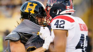 Hamilton Tiger-Cats running back Ante Litre (34) and Montreal Alouettes linebacker Tyrell Richards (42) rough it up during first half CFL football game action in Hamilton, Ont. on Friday, June 27, 2025. (Peter Power/THE CANADIAN PRESS)