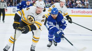 Boston Bruins' Tanner Jeannot (84) and Toronto Maple Leafs' William Nylander (88) battle for the puck during third period NHL hockey action in Toronto, on Saturday, Nov. 8, 2025. (Sammy Kogan/CP)