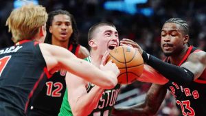 Boston Celtics' Payton Pritchard (11) drives between Toronto Raptors' Gradey Dick (left to right) Collin Murray-Boyles (12) and Jamal Shead (23) during second half NBA basketball action in Toronto on Saturday, Dec. 20, 2025. (Frank Gunn/CP)