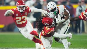 Kansas City Chiefs linebacker Nick Bolton (32) makes a hit on Denver Broncos running back RJ Harvey during the first half of an NFL football game Thursday, Dec. 25, 2025, in Kansas City, Mo. (AP Photo/Charlie Riedel)