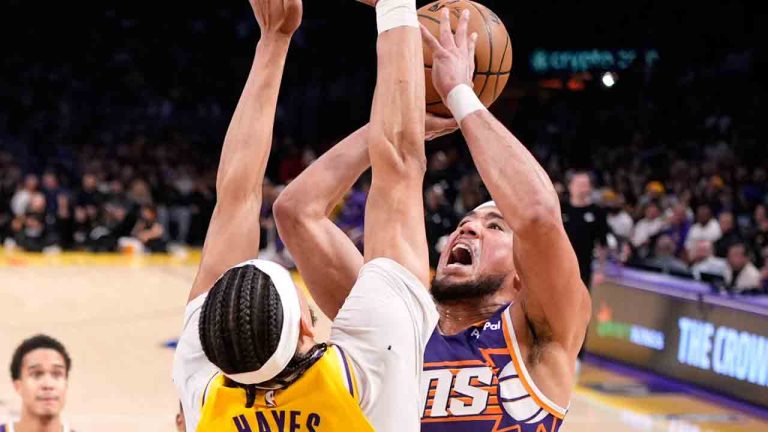 Phoenix Suns guard Devin Booker, right, shoots as Los Angeles Lakers center Jaxson Hayes defends during the first half of an NBA basketball game Monday, Dec. 1, 2025, in Los Angeles. (Mark J. Terrill/AP)