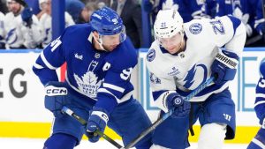 Tampa Bay Lightning's Brayden Point (21) takes the puck from Toronto Maple Leafs' John Tavares (91) during first period NHL action in Toronto, Monday, Dec. 8, 2025. (Chris Young/CP)
