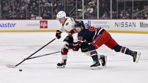 Ottawa Senators' Tim Stulzle (18) carries the puck past Winnipeg Jets' Cole Perfetti (91) during the first period of their NHL hockey game in Winnipeg, Monday, Dec. 15, 2025. THE CANADIAN PRESS/Fred Greenslade