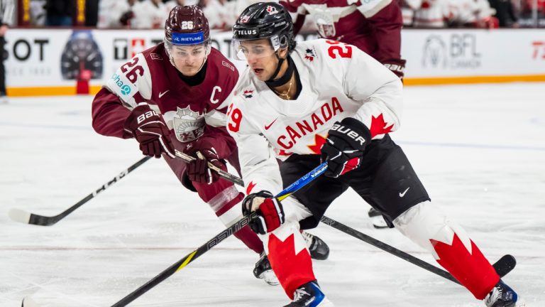 Canada's Michael Hage skates with the puck while Latvia's Oskars Briedis defends during third period IIHF World Junior Championship hockey action, in Minneapolis, Saturday, Dec. 27, 2025. (Christopher Katsarov/CP)