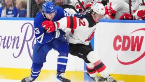 Toronto Maple Leafs right wing Easton Cowan (53) and New Jersey Devils centre Cody Glass (12) battle alongs the boards for control of the puck during first period NHL hockey action in Toronto on Tuesday Dec. 30, 2025. (Frank Gunn/CP)
