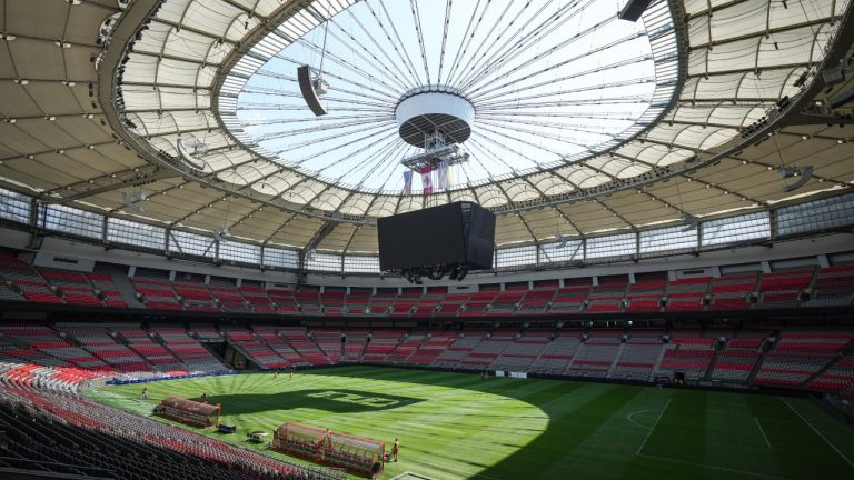 Stadium staff prepare temporary grass that was laid on top of artificial turf at BC Place stadium for a friendly soccer match between MLS soccer's Vancouver Whitecaps and League One's Wrexham, in Vancouver, on Friday, July 26, 2024. The stadium, which is undergoing hundred of millions of dollars of renovations, is also scheduled to host seven matches during the 2026 FIFA World Cup. THE CANADIAN PRESS/Darryl Dyck