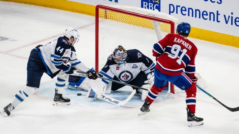 Winnipeg Jets goaltender Eric Comrie (1) makes a save on Montreal Canadiens' Oliver Kapanen (91) while Jets' Josh Morrissey (44) defends during second period NHL hockey action, in Montreal on Wednesday, Dec. 3, 2025. (Christopher Katsarov/CP)