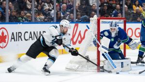 Vancouver Canucks' goaltender Kevin Lankinen (32) stops Utah Mammoth's Michael Carcone (53) during the second period of an NHL hockey game in Vancouver, on Friday, December 5, 2025. (Ethan Cairns/CP)
