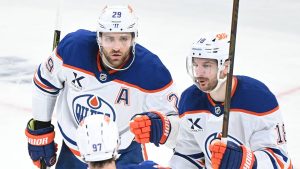 Edmonton Oilers' Zach Hyman (18) celebrates with teammates Leon Draisaitl (29) and Connor McDavid (97) after scoring against the Montreal Canadiens during third period NHL hockey action in Montreal, Sunday, Dec. 14, 2025. (Graham Hughes/CP)