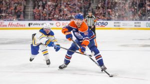 Edmonton Oilers Connor McDavid (97) keeps ahead of Buffalo Sabres Zach Benson (6) during second period NHL action in Edmonton, Tuesday, Dec. 9, 2025. (Amber Bracken/CP)