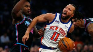 Miami Heat guard Davion Mitchell, left, defends against New York Knicks guard Jalen Brunson (11) during the first half of an NBA basketball game Sunday, Dec. 21, 2025, in New York. (AP Photo/John Munson)
