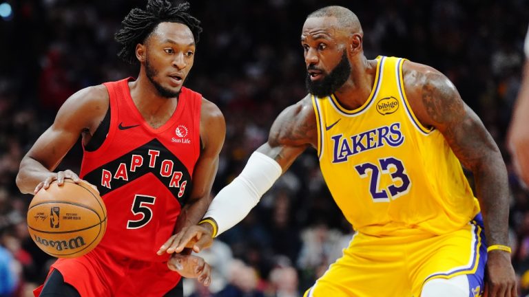 Toronto Raptors' Immanuel Quickley (5) protects the ball from Los Angeles Lakers' LeBron James (23) during first half NBA basketball action in Toronto on Thursday, Dec. 4, 2025. THE CANADIAN PRESS/Frank Gunn