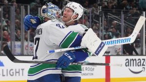 Vancouver Canucks right wing Brock Boeser, facing, celebrates a win in a shootout against the Seattle Kraken with goaltender Kevin Lankinen, left, after an NHL hockey game Monday, Dec. 29, 2025, in Seattle. (Lindsey Wasson/AP)