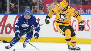 Pittsburgh Penguins forward Sidney Crosby (87) breaks up ice past Toronto Maple Leafs forward Max Domi (11) during first period NHL hockey action in Toronto on Tuesday, Dec. 23, 2025. (Nathan Denette/CP)