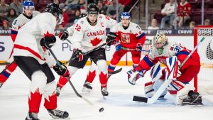 Canada's Michael Misa (7) attacks Czechia goaltender Michal Orsulak (30) while Canada's Porter Martone (22) stands in front of the net during second period IIHF World Junior Championship hockey action, in Minneapolis, Friday, Dec. 26, 2025. (Christopher Katsarov/CP)
