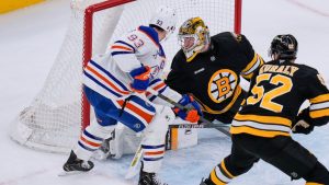 Edmonton Oilers center Ryan Nugent-Hopkins (93) scores against Boston Bruins goaltender Jeremy Swayman, top right, during the first period of an NHL hockey game, Thursday, Dec. 18, 2025, in Boston. (AP Photo/Charles Krupa)