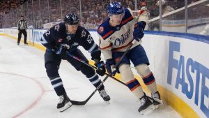 Winnipeg Jets' Nino Niederreiter (62) and Edmonton Oilers' Ty Emberson (49) battle for the puck during first period NHL action in Edmonton on Saturday, December 6, 2025. (Jason Franson/CP)