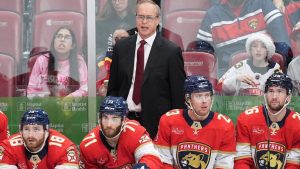 Florida Panthers head coach Paul Maurice stands behind players left wing Noah Gregor (18), centre Luke Kunin (71), centre Carter Verhaeghe (23), and defenceman Uvis Balinskis (26) during the third period of an NHL hockey game against the Calgary Flames, Friday, Nov. 28, 2025, in Sunrise, Fla. (Rebecca Blackwell/AP)