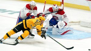 Pittsburgh Penguins' Sidney Crosby (87) reaches for the puck during the first period of an NHL hockey game against the Montréal Canadiens, Thursday, Dec. 11, 2025, in Pittsburgh. (Matt Freed/Pittsburgh Post-Gazette via AP)